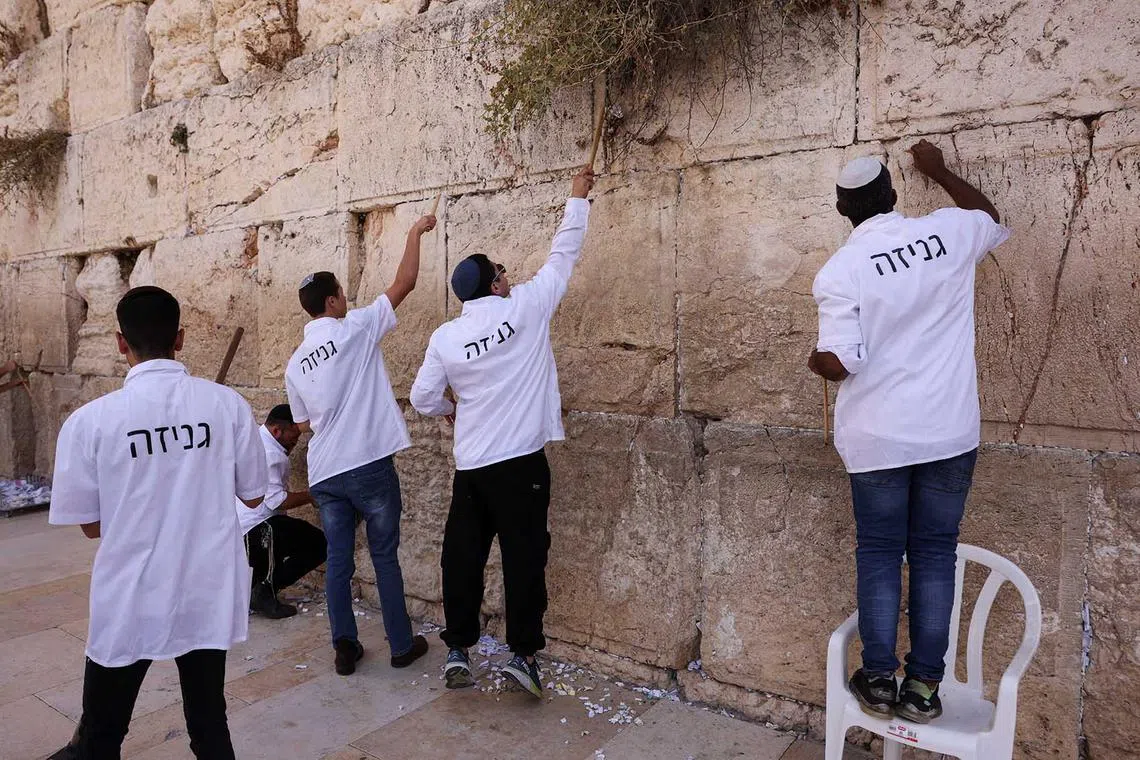 Workers clear notes to God that were placed in the cracks of the Western Wall, Judaism's holiest prayer site, to make space for new notes ahead of the Jewish New Year, in Jerusalem's Old City, on Sept 10.