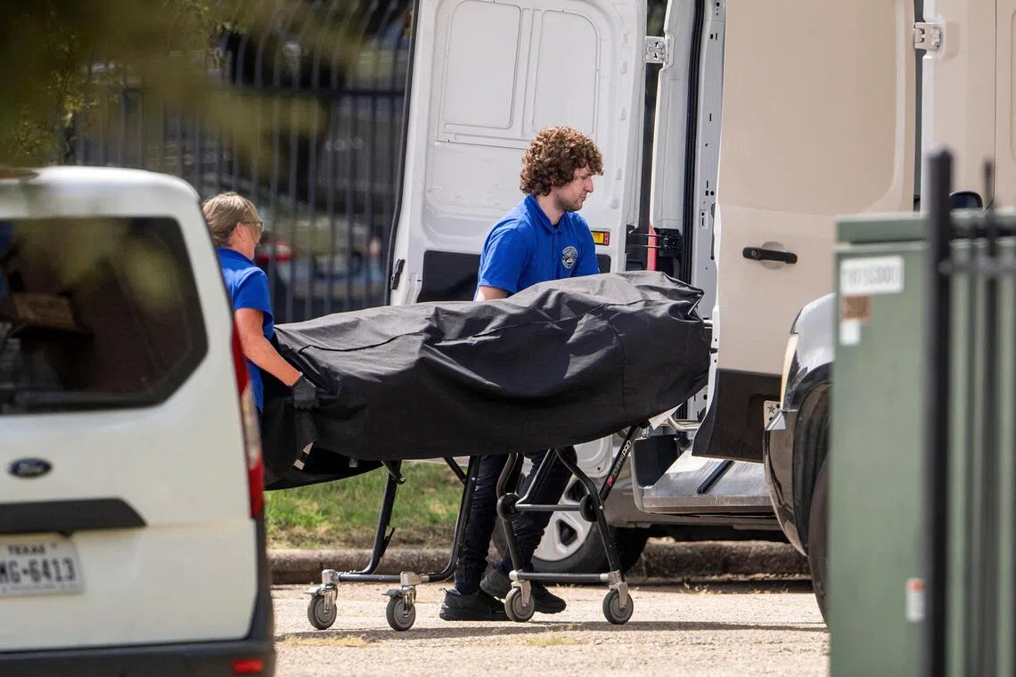 Personnel loading the body of the alleged gunman into the back of a van at the scene of the shooting, in Dallas, Texas, on Sept 24.