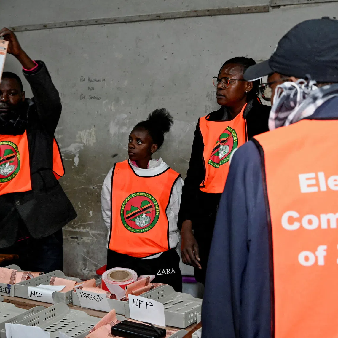 FILE PHOTO: An election official displays a ballot paper as observers look on during the counting of votes after the polls closed at a polling station in Lusaka, Zambia, during Zambia's general elections, including the presidential election, August 13, 2026. REUTERS/Moses Mwape/File Photo