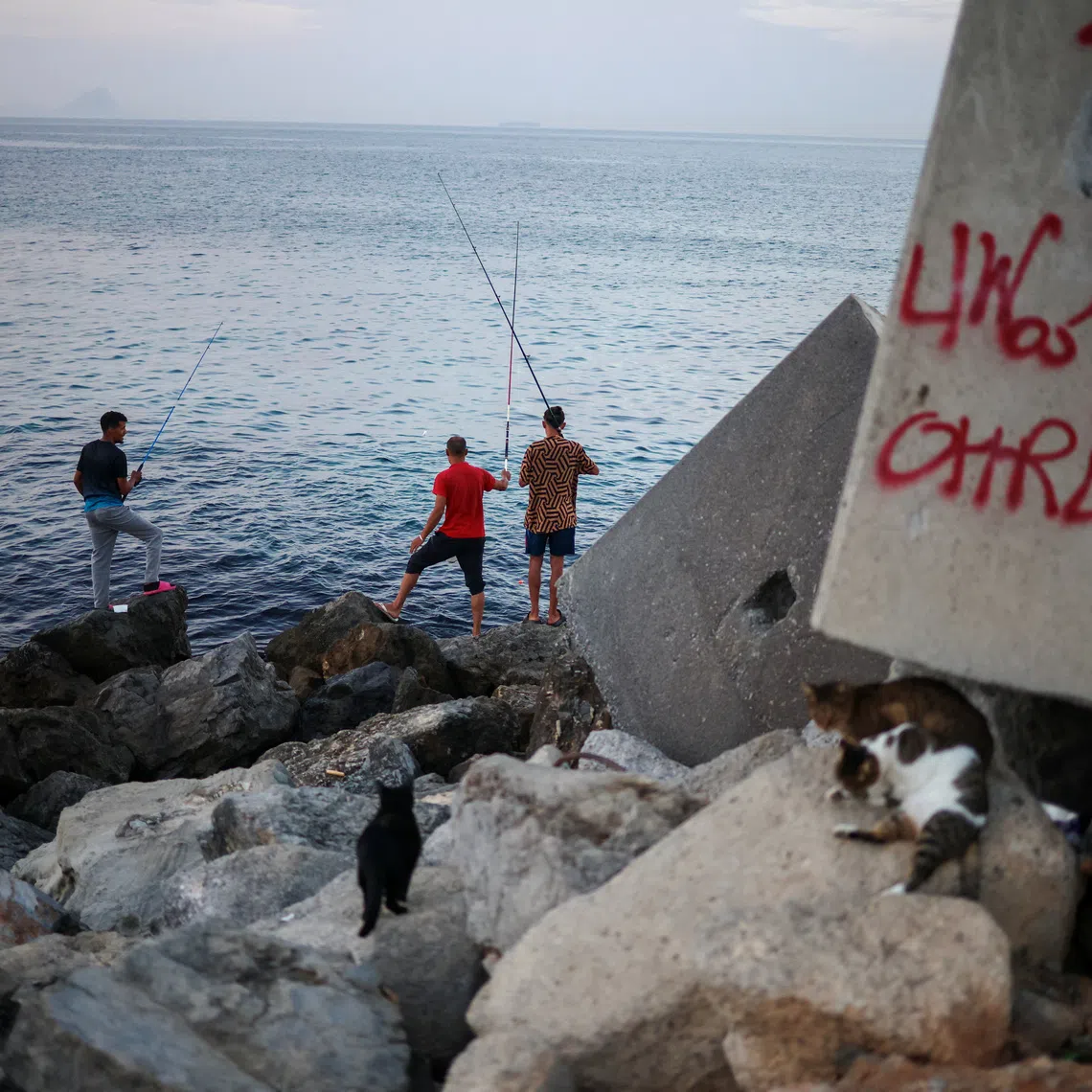 Migrants fish in Trampolin Beach following recent mass crossings of migrants from Morocco to Ceuta, Spain, September 29, 2026. REUTERS/Pedro Nunes