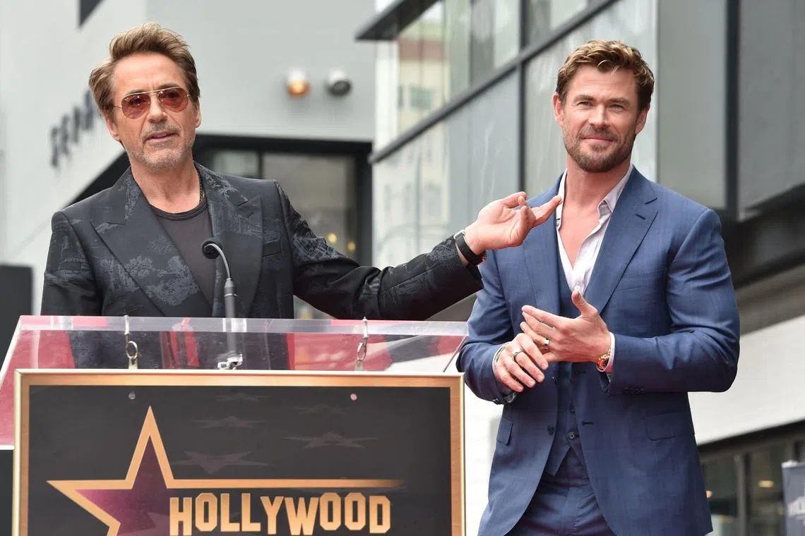 US actor Robert Downey Jr. (L) speaks alongside Australian actor Chris Hemsworth during his Walk of Fame ceremony in Hollywood, California, on May 23, 2024. (Photo by Chris DELMAS / AFP)