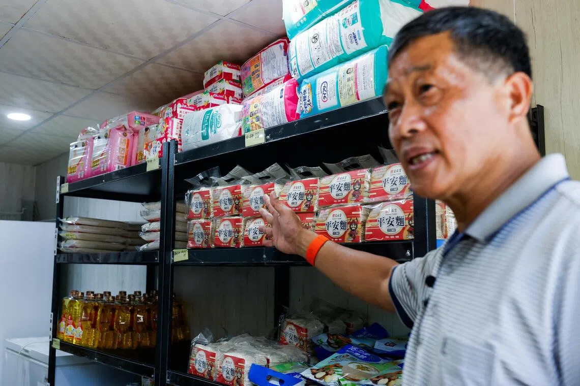 Retired police officer Yen Min-ching shows emergency supplies stored at a community activity centre in Penghu.