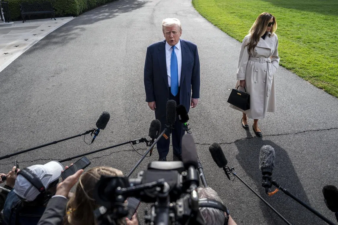 Accompanied by first lady Melania Trump, US President Donald Trump stops to speak to reporters as he heads to Italy, for the funeral of Pope Francis.