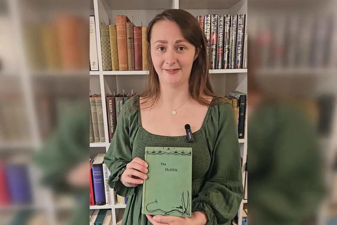 Caitlin Riley, a rare books specialist, poses with one of the first editions of The Hobbit by J.R.R. Tolkien.