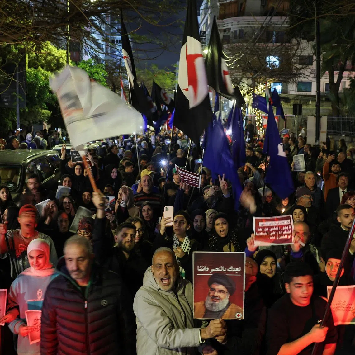 A person raising a portrait of late Hezbollah leader Hassan Nasrallah during a demonstration in support of Hezbollah and Iran in Beirut on March 27.