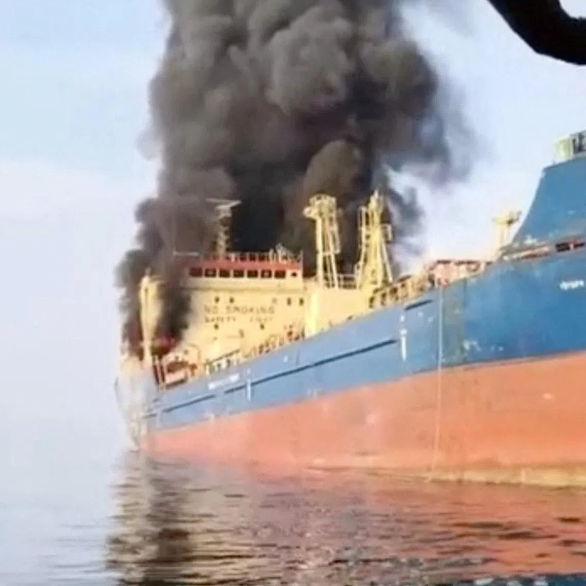 Smoke billows from an oil tanker under U.S. sanctions, that was hit off Oman's Musandam peninsula, in this screen grab from a video obtained by REUTERS on March 1, 2026.
