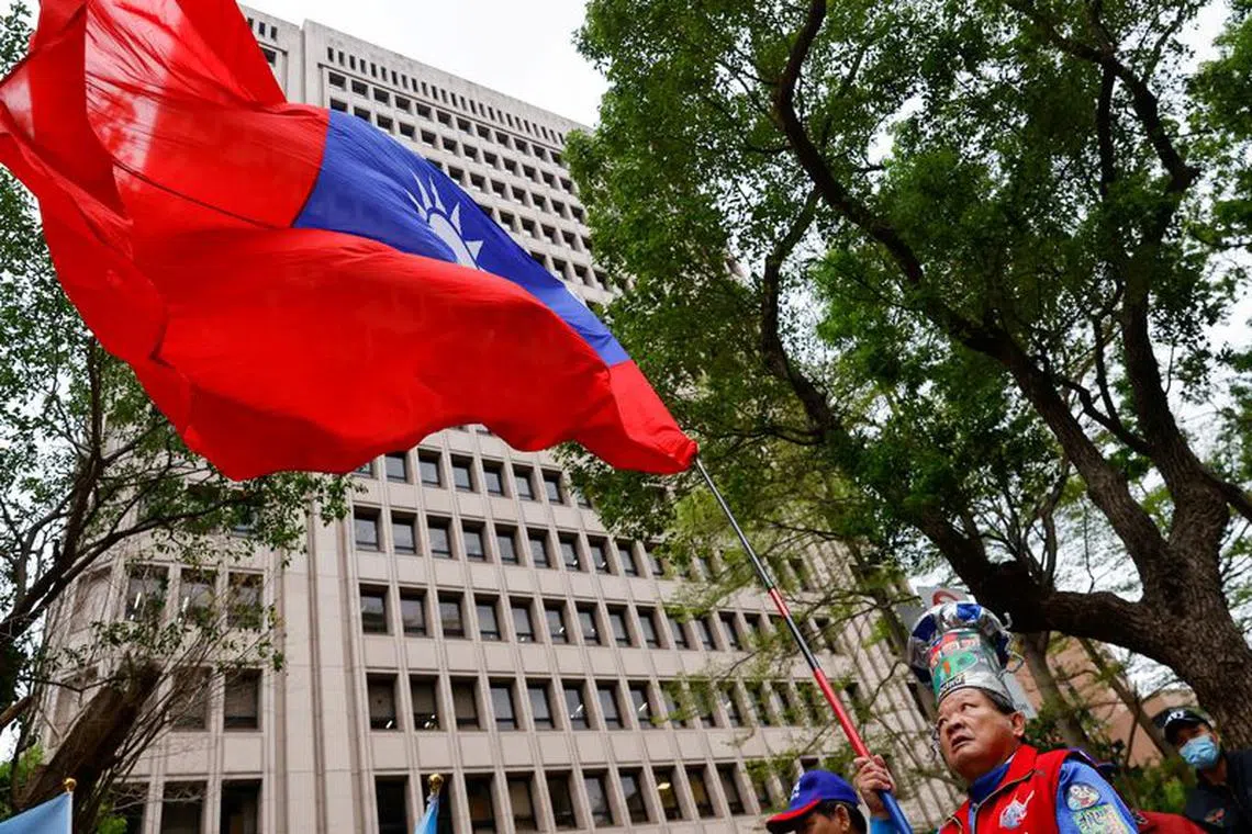 FILE PHOTO: A supporter of the main opposition party Kuomintang (KMT) waves a Taiwanese flag outside of the Central Election Commission in Taipei, Taiwan November 24, 2023. REUTERS/Ann Wang/File Photo