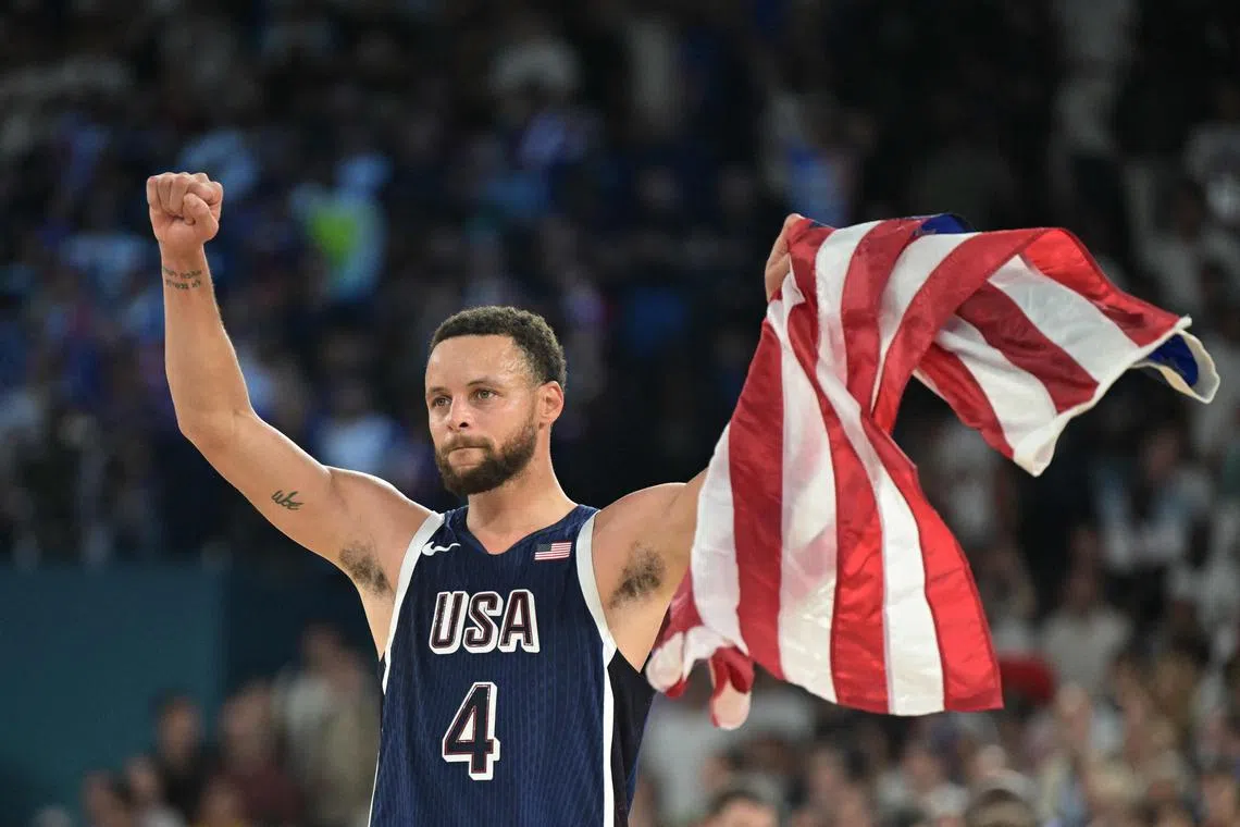 Stephen Curry celebrating with the US flag after the United States won gold. 
