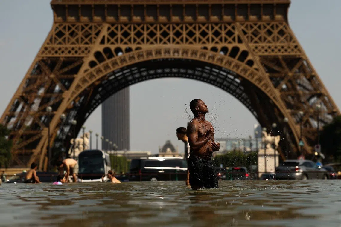 People cool off in the Trocadero Fountain near to the Eiffel Tower as temperatures rise during a heatwave affecting a large part of the country, in Paris, France, June 24, 2026. REUTERS/Gonzalo Fuentes
