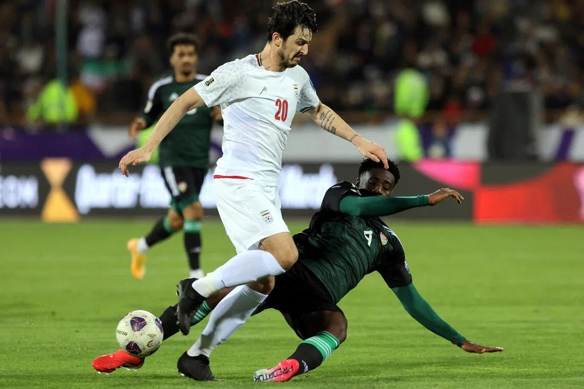 Iran's Sardar Azmoun getting tackled by United Arab Emirates' Kouame Kouadio in March 2025.