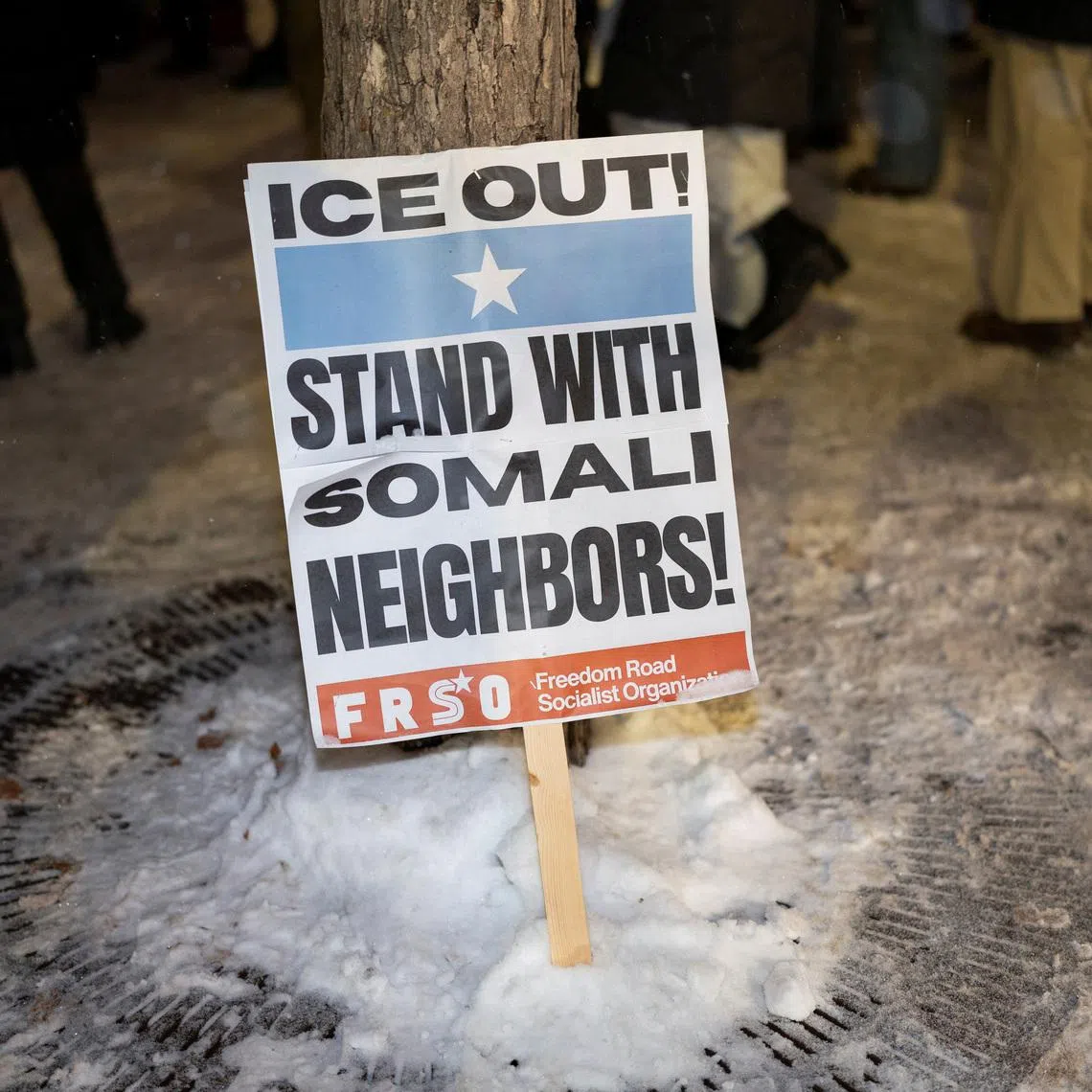 A sign rests against a tree as demonstrators rally to protest Immigration and Customs Enforcement (ICE), amid a reported federal immigration operation targeting the Somali community, in Minneapolis, Minnesota, U.S. December 8, 2025.  REUTERS/Tim Evans