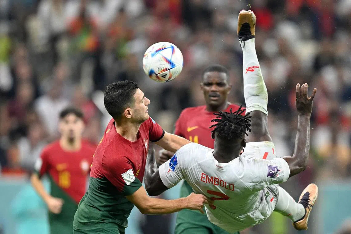 Portugal's defender #02 Diogo Dalot (L) fights for the ball Switzerland's forward #07 Breel Embolo during the Qatar 2022 World Cup round of 16 football match between Portugal and Switzerland at Lusail Stadium in Lusail, north of Doha on Dec 6, 2022. 