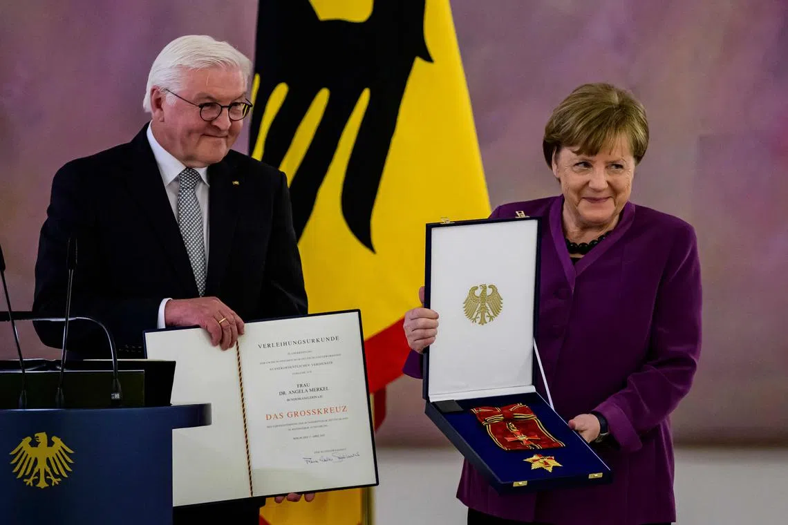 German President Frank-Walter Steinmeier (L) awards the Order of Merit to former German Chancellor Angela Merkel at the Bellevue presidential palace in Berlin on Monday.