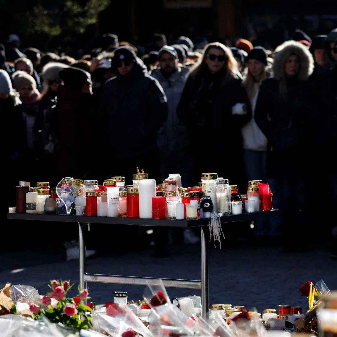 People gather around a makeshift memorial outside the \"Le Constellation\" bar, after a deadly fire and explosion during a New Year's Eve party, in the upscale ski resort of Crans-Montana, in southwestern Switzerland, January 4, 2026. REUTERS/Lisa Leutner
