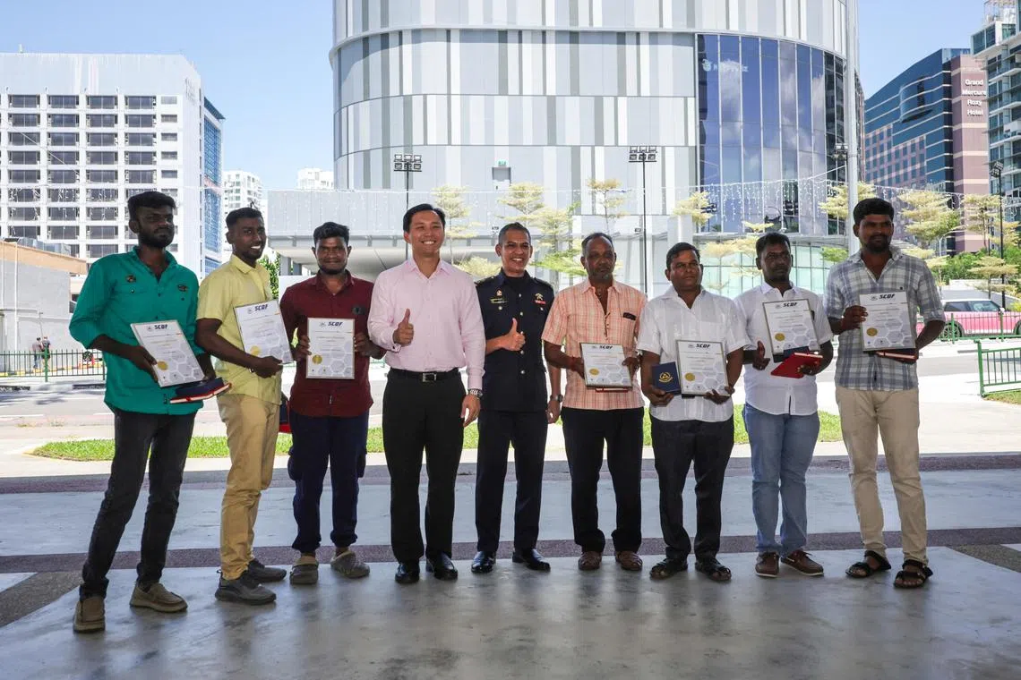 The workers were presented the SCDF Community Lifesaver Award certificate and medallion from Minister of State for Home Affairs and Marine Parade-Braddell Heights GRC MP Goh Pei Ming (fourth from left).
