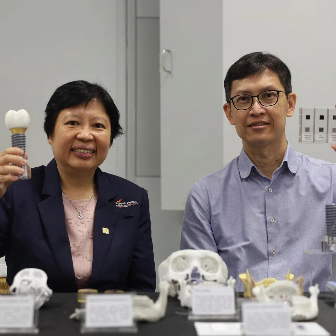 (Left to right) CEO National Dental Centre Singapore Professor Goh Bee Tin and Professor Ng Kee Woei, Chair, School of Materials Science & Engineering holding up a model of a dental implant and a sample of a nanocomposite coating during the opening of the NTI-NTU corporate laboratory on April 20, 2026.