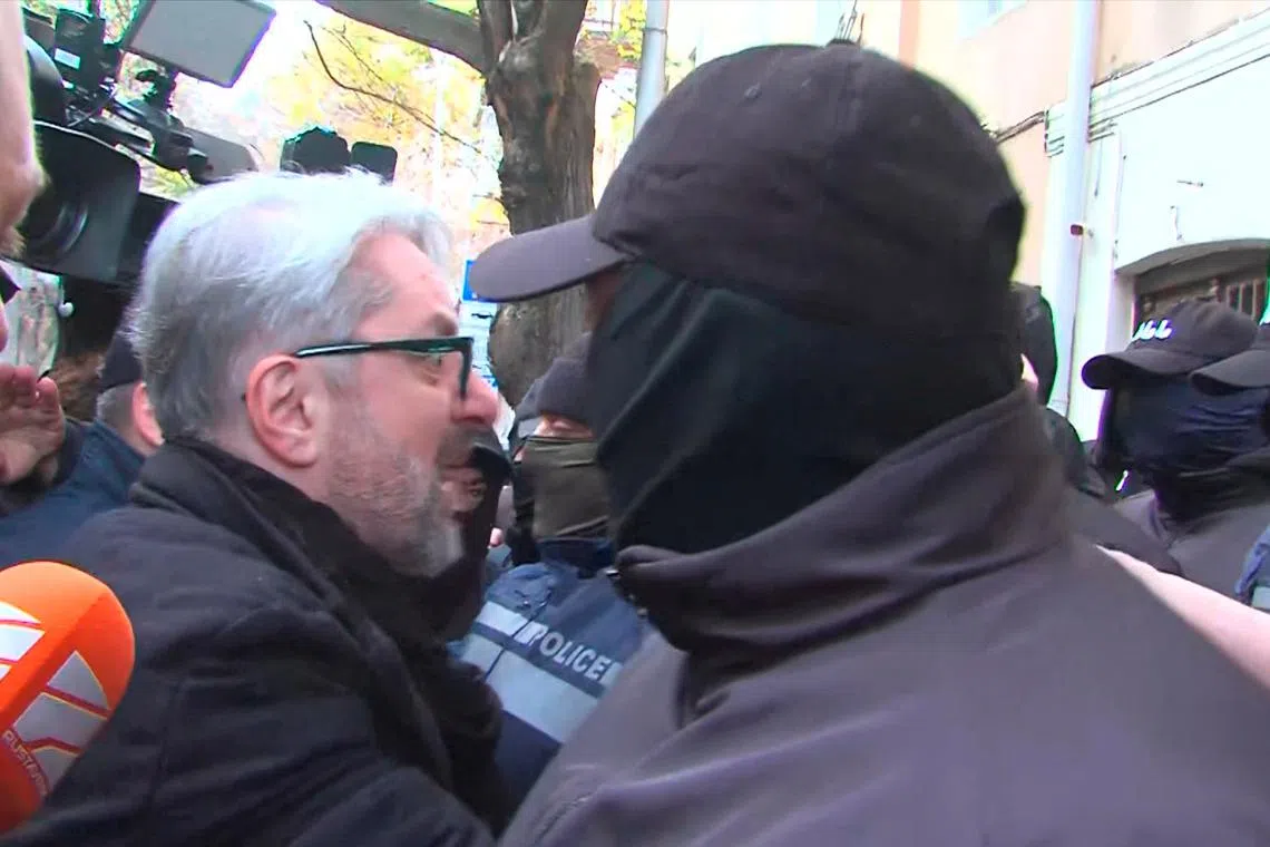 Nika Gvaramia, leader of the Coalition for Change party, is seen surrounded by police officers before his detention in Tbilisi, Georgia December 4, 2024, in this still image from video.  Formula TV/Handout via REUTERS
