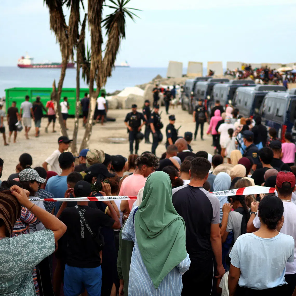 Migrants wait in line to receive food from the Red Cross at Trampolin Beach following recent mass crossings of migrants from Morocco to Ceuta, Spain, September 30, 2026. REUTERS/Pedro Nunes