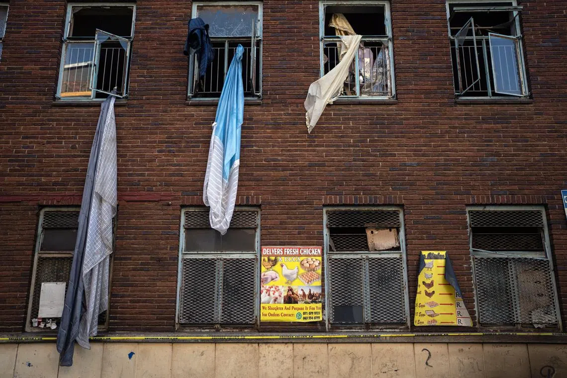 Sheets and blankets used by residents to escape remain on Friday, Sept. 1, 2023, at the scene of a fire in downtown Johannesburg that killed at least 74 people the previous morning. The derelict building had been taken over by informal landlords.  (Joao Silva/The New York Times)