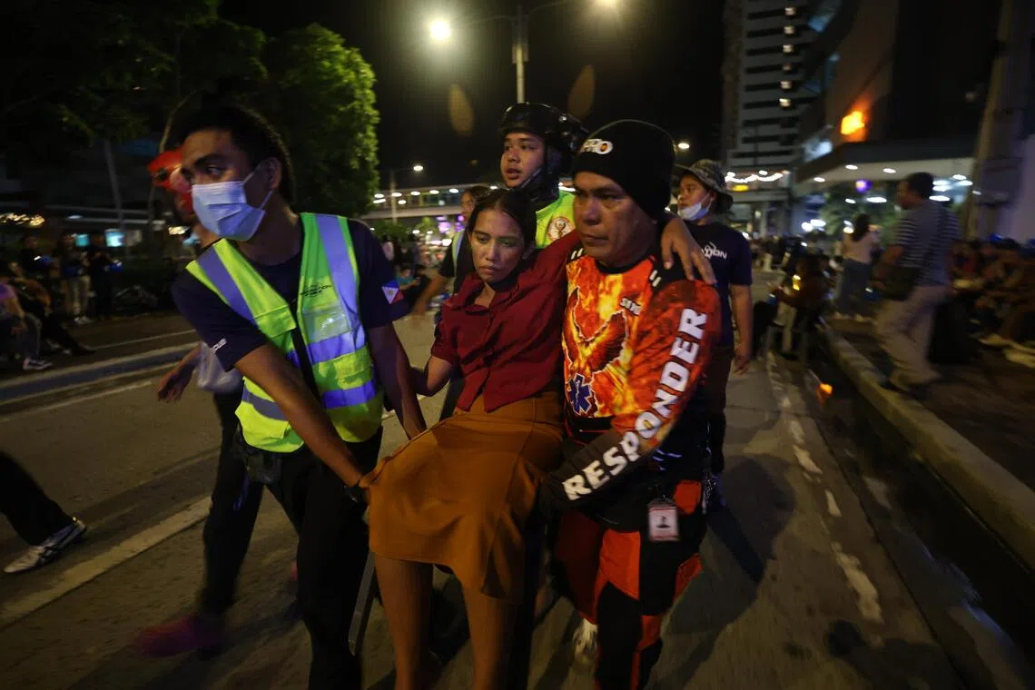 Rescuers carrying an injured woman in Ilo-Ilo city, after an earthquake hit the central Philippines on Sept 30.
