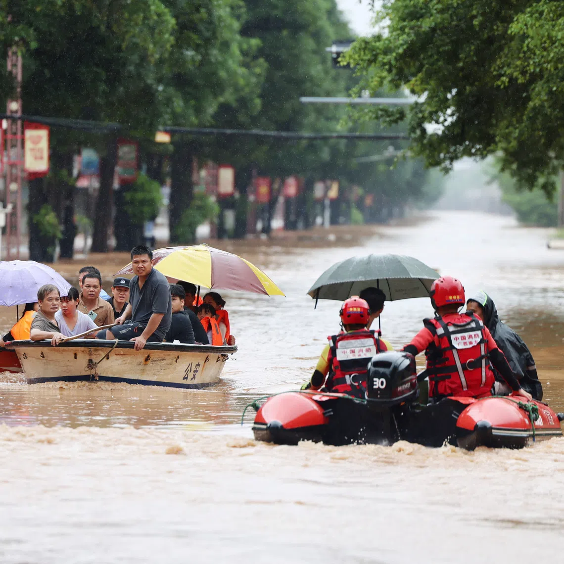 Rescue workers evacuate flood-affected residents by boat after heavy rainfall in Ningming county on Aug 23.