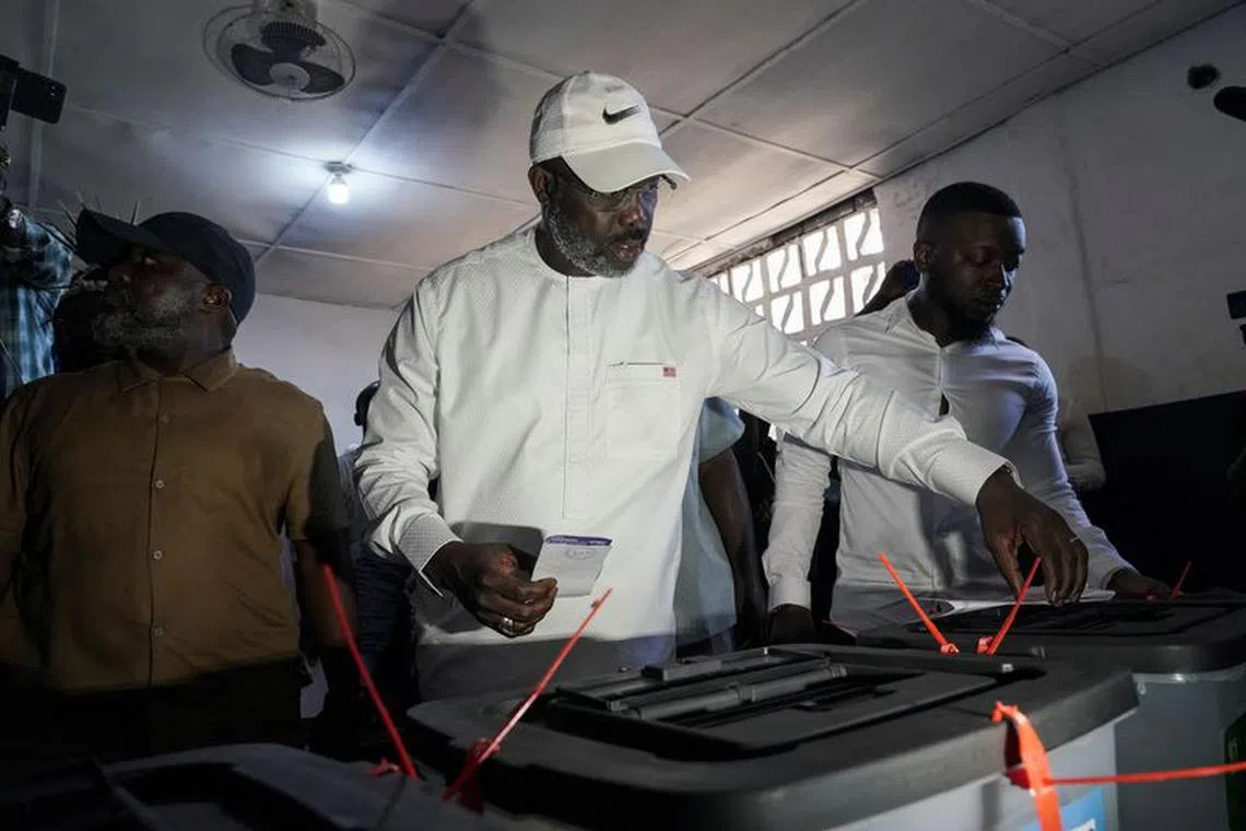 Leader of Liberia's ruling party Coalition for Democratic Change(CDC), President and former soccer player George Weah, prepares to cast his vote during the presidential elections in Monrovia, Liberia  October 10, 2023. REUTERS/Carielle Doe/File Photo