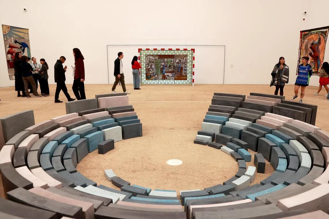 People view works during the opening of the exhibition 'Football and Art: A Shared Emotion' in Mexico City. Recycled seats from the former Azteca Stadium, scaled-down dirt football fields, and historical archives of football around the world are among the hundred works on display at the Jumex Museum in the lead-up to the 2026 World Cup. 
