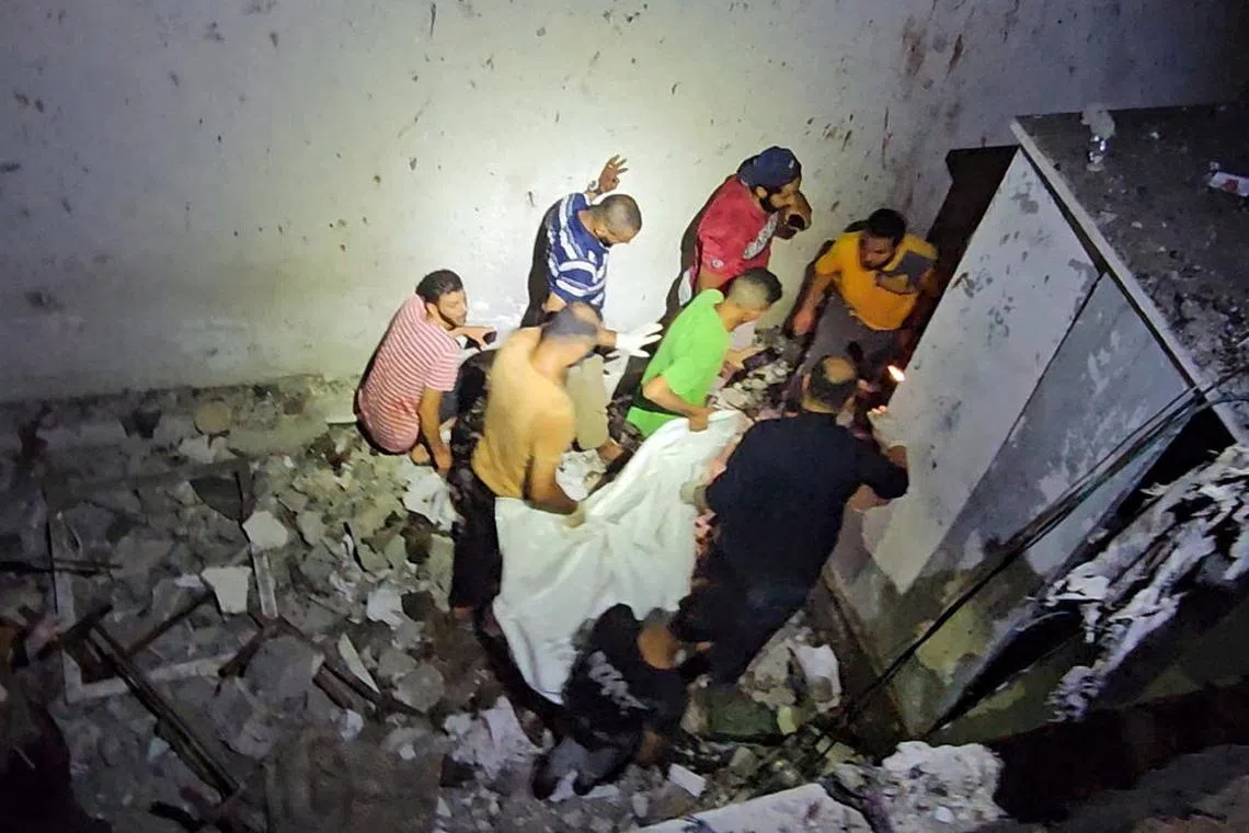 People carry the body of a Palestinian killed in an Israeli strike on a UNRWA school sheltering displaced people, amid the Israel-Hamas conflict, in Nuseirat refugee camp in the central Gaza Strip, in this screengrab taken from a video June 6, 2024. REUTERS/Reuters TV