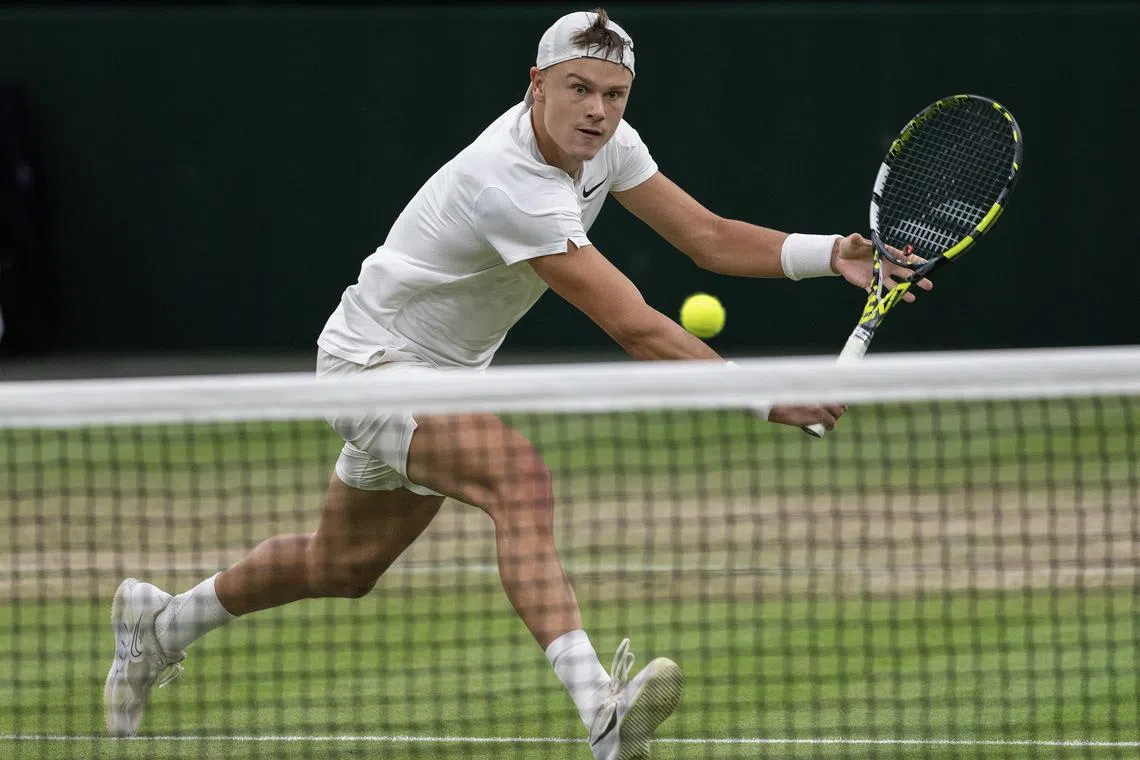 FILE PHOTO: Jul 8, 2024; London, United Kingdom; Holger Rune of Denmark returns a shot during his match against Novak Djokovic of Serbia (not shown) on day eight of The Championships at All England Lawn Tennis and Croquet Club. Mandatory Credit: Susan Mullane-USA TODAY Sports