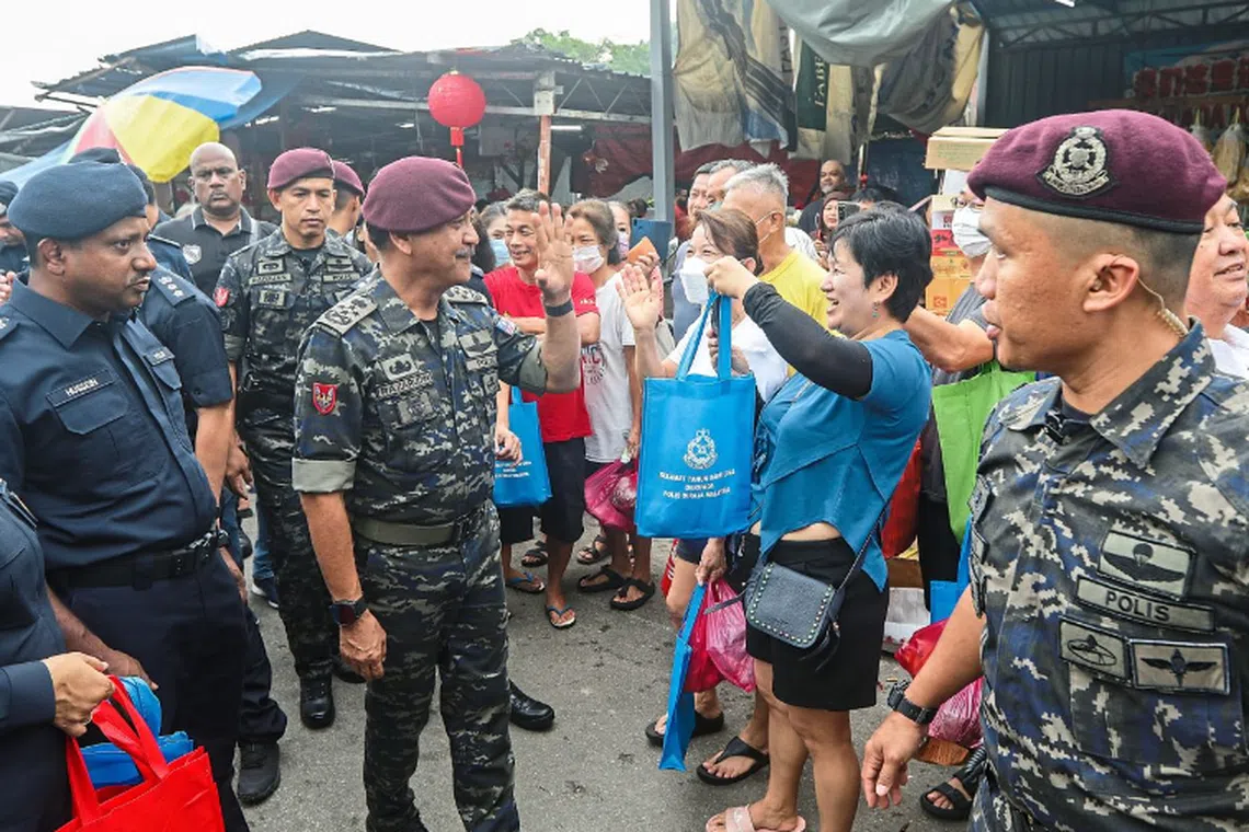 Mr Razarudin (fourth left) waving to a crowd of shoppers at Pandamaran market in Klang. With him is Selangor police chief Comm Datuk Hussein Omar Khan (left). — IZZRAFIQ ALIAS/The Star