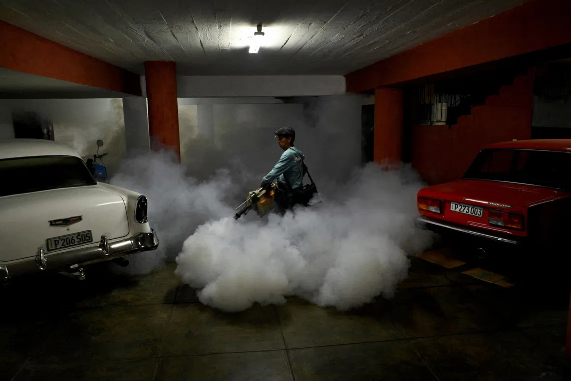 State worker Arnaldo Alvarez uses a fogging machine to fumigate inside a garage as part of a public health campaign against the spread of mosquito-transmitted virus that causes Chikungunya, in Havana, Cuba November 13, 2025. REUTERS/Norlys Perez     TPX IMAGES OF THE DAY