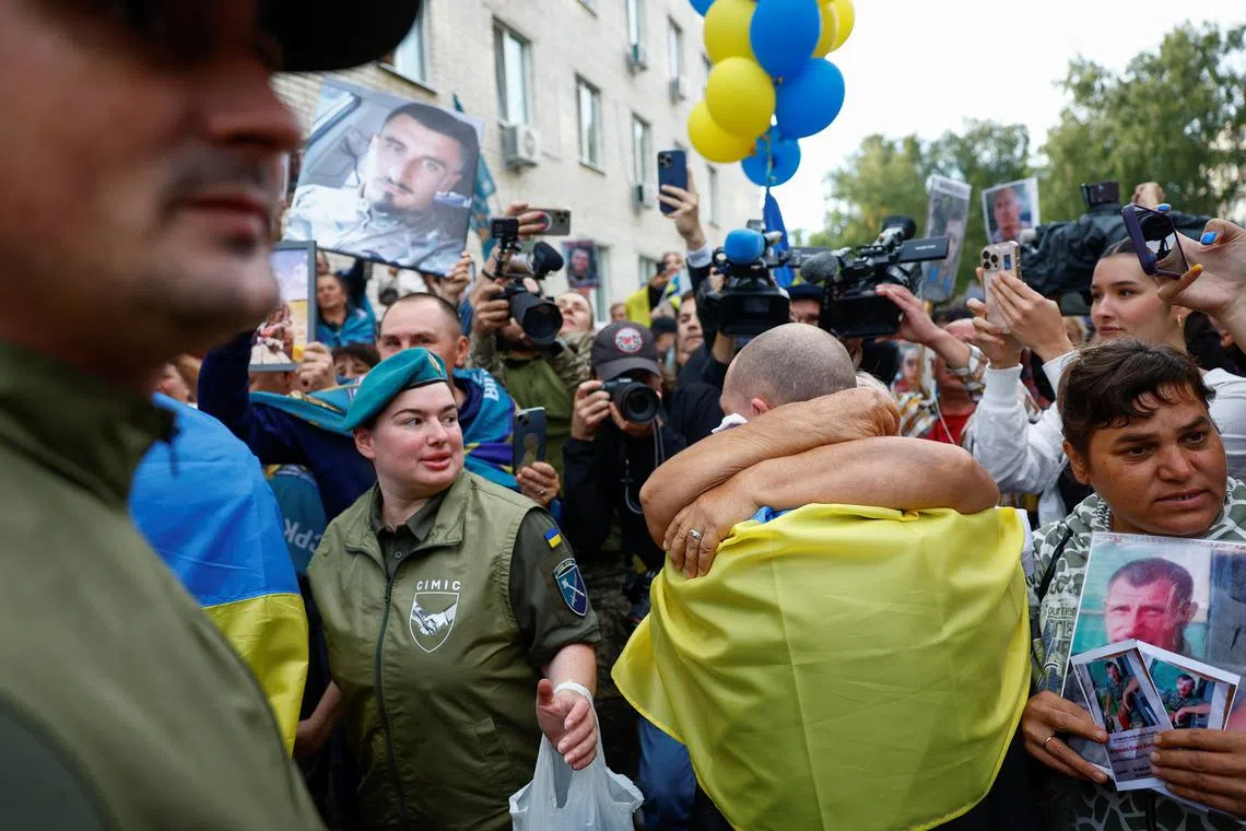 Olha embraces her son Yevhen, a freed Ukrainian prisoner of war (POW), as he left a bus after a swap, amid Russia's attack on Ukraine, in an undisclosed location in Ukraine, August 24, 2025. REUTERS/Valentyn Ogirenko