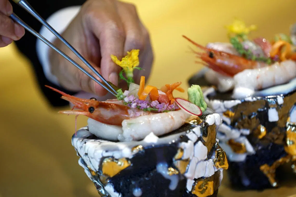 Kazuyuki Tanioka, the owner of Japanese cuisine Toya restaurant, prepares a sashimi dish, during an interview with Reuters, in Beijing, China July 25, 2023. REUTERS/Tingshu Wang