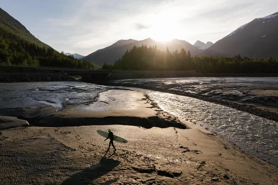 Pete Beachy walks along the shore of the Turnagain Arm near Bird Point, 48km south-east of Anchorage, Alaska on June 18, 2026. The tidal bore that rockets up the Turnagain Arm south of Anchorage can carry a surfer for an hour; it can also kill.