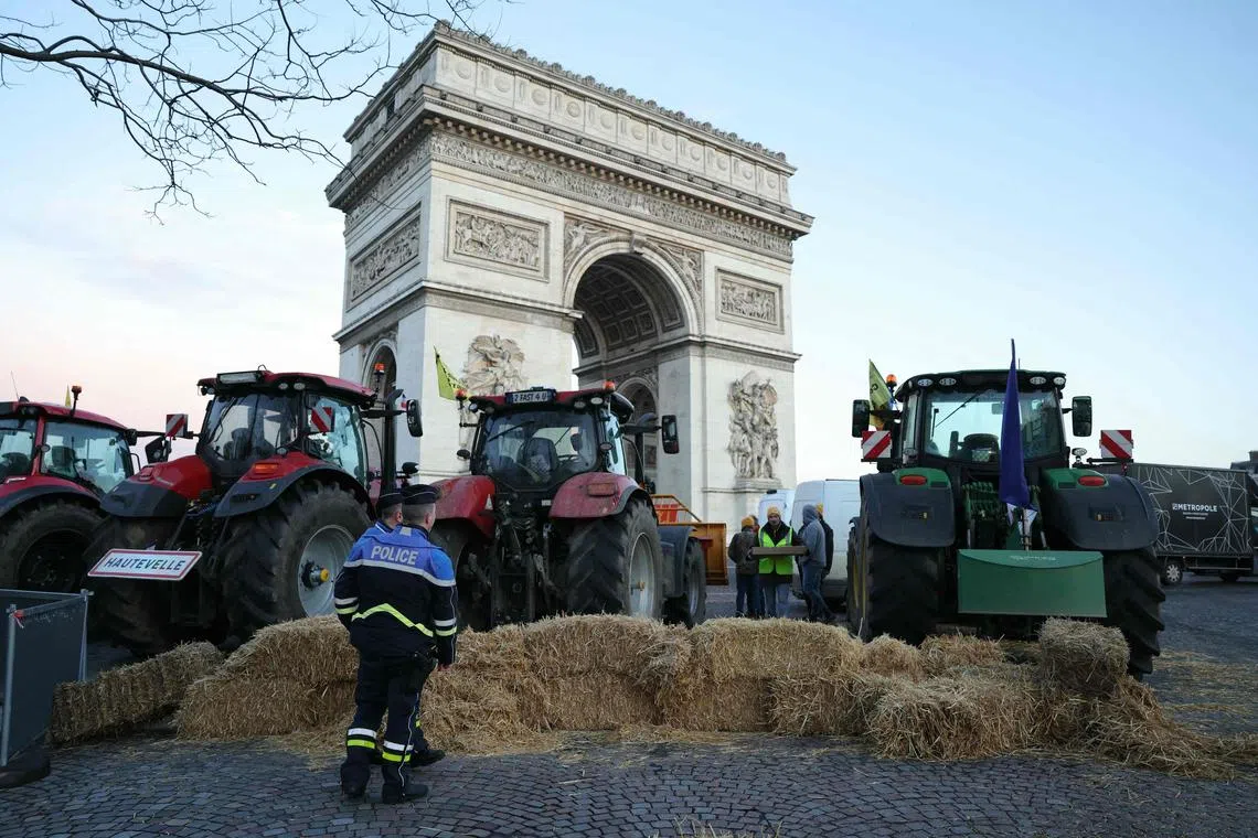 Policemen look at tractors seen parked on the Champs-Elysees Avenue during a protest by the French farmers' union in Paris on March 1.