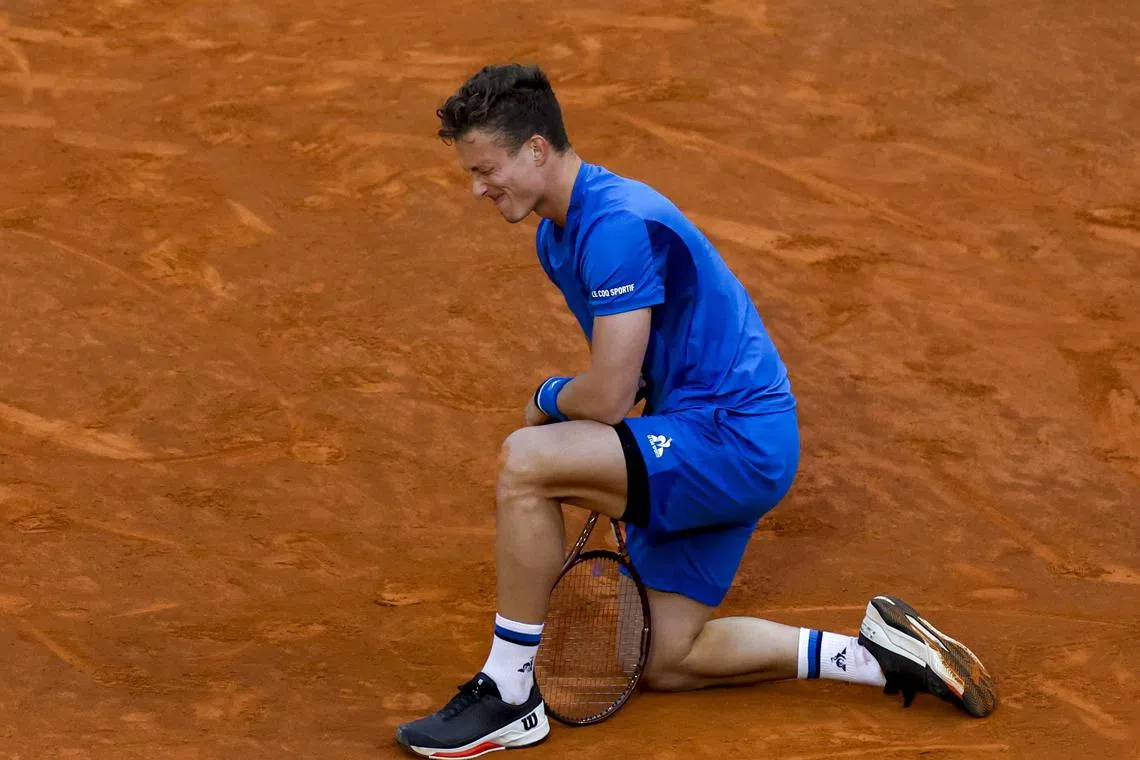 Jiri Lehecka of Czech Republic grimaces after suffering a back injury that forced him to retire from his semi-final match against Felix Auger-Aliassime of Canada at the Madrid Open.
