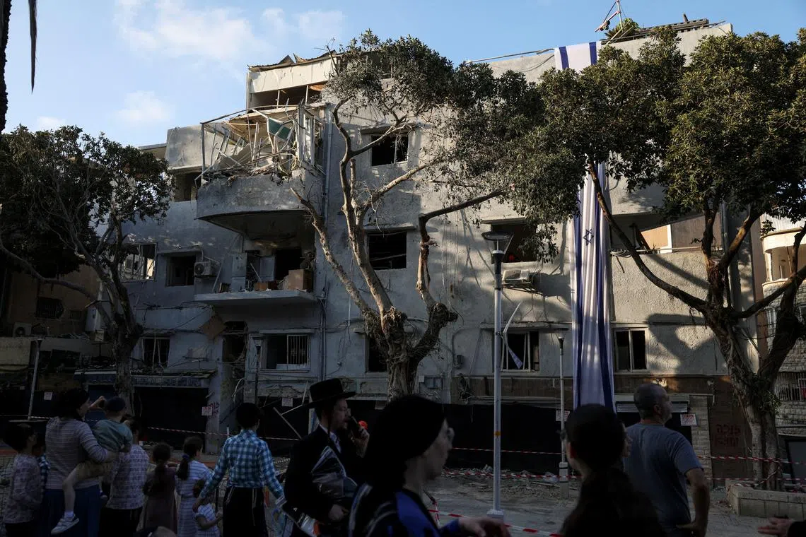 People gather at an impact site following Iran's strike on Israel, amid the Iran-Israel conflict, in Haifa, Israel, on June 22, 2025. 