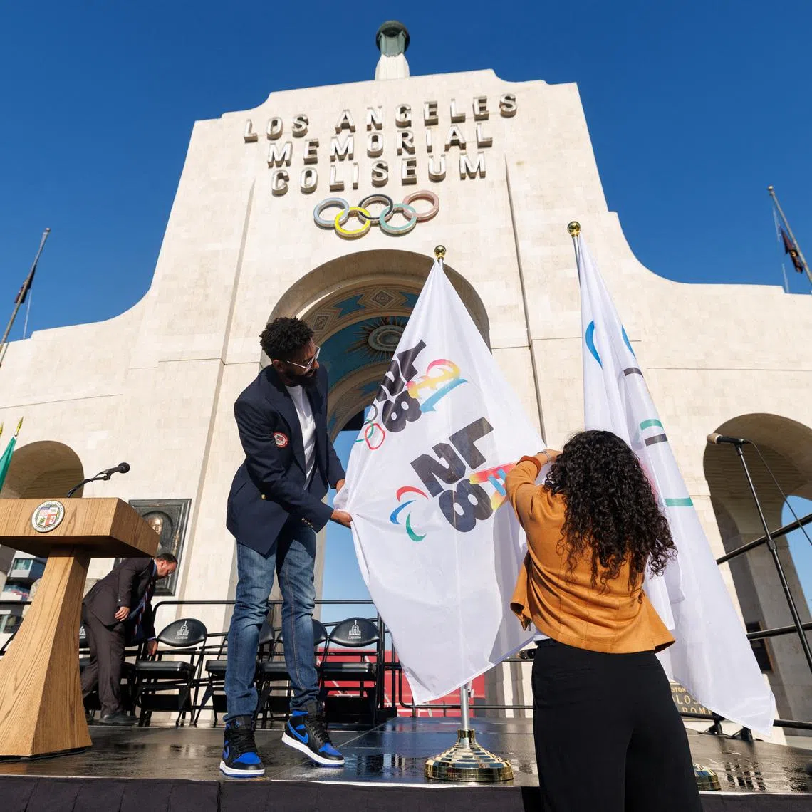 Workers from LA28 setup Olympic and Paralympic flags outside the Los Angeles Coliseum in Los Angeles, California, U.S., May 8, 2025.
