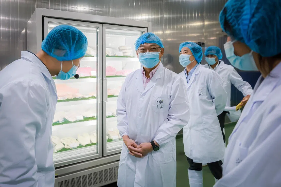 Trade and Industry Minister Gan Kim Yong (centre) touring Fish International Sourcing House’s new processing facility in Boon Lay, on Jan 5, 2023.