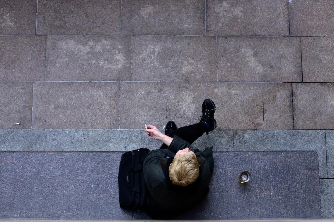FILE PHOTO: A person smokes a cigarette in Canary Wharf in London, Britain May 10, 2017. REUTERS/Marika Kochiashvili/File Photo