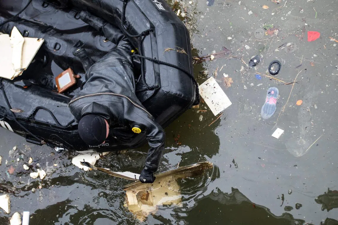 Police divers collecting debris near where a helicopter crashed in the Hudson River, on April 11.