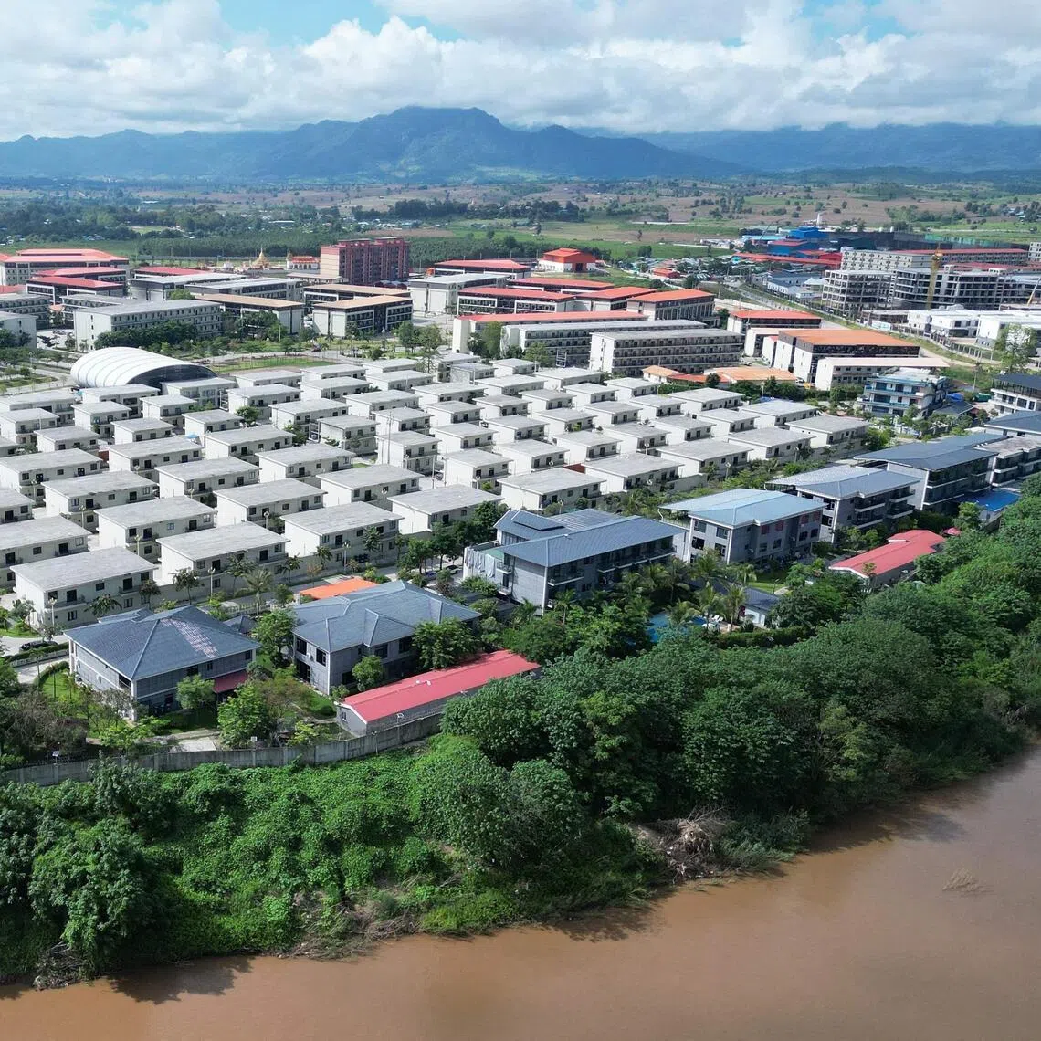 (FILES) This aerial photo taken on September 17, 2025 shows the KK Park complex in Myanmar's eastern Myawaddy township, as pictured from Mae Sot district in Thailand's border province of Tak. China is moving against the cyberscam tycoons making fortunes in Southeast Asia, driven by mounting public pressure and Beijing's desire to keep control of judicial processes, analysts say. 
In 2025, a series of crackdowns largely driven by Beijing -- which wields significant economic and diplomatic influence in the region -- saw thousands of workers released from scam centres in Myanmar and Cambodia and repatriated to their home countries, many of them to China.
Now Beijing has turned its focus to the bosses at the apex of the criminal pyramids, netting its biggest player so far with the arrest and extradition of Chen Zhi from Cambodia in January 2026. (Photo by Lillian SUWANRUMPHA / AFP) / TO GO WITH Cambodia-China-cybercrime-diplomacy, FOCUS by Sally JENSEN