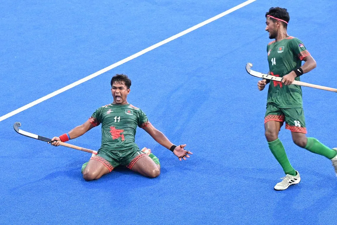 Bangladeshi player Hasan Md (left) celebrates after he scored a field goal against China in the Men's Junior Asian Hockey Federation Cup Final on June 23 at Sengkang Hockey Stadium .