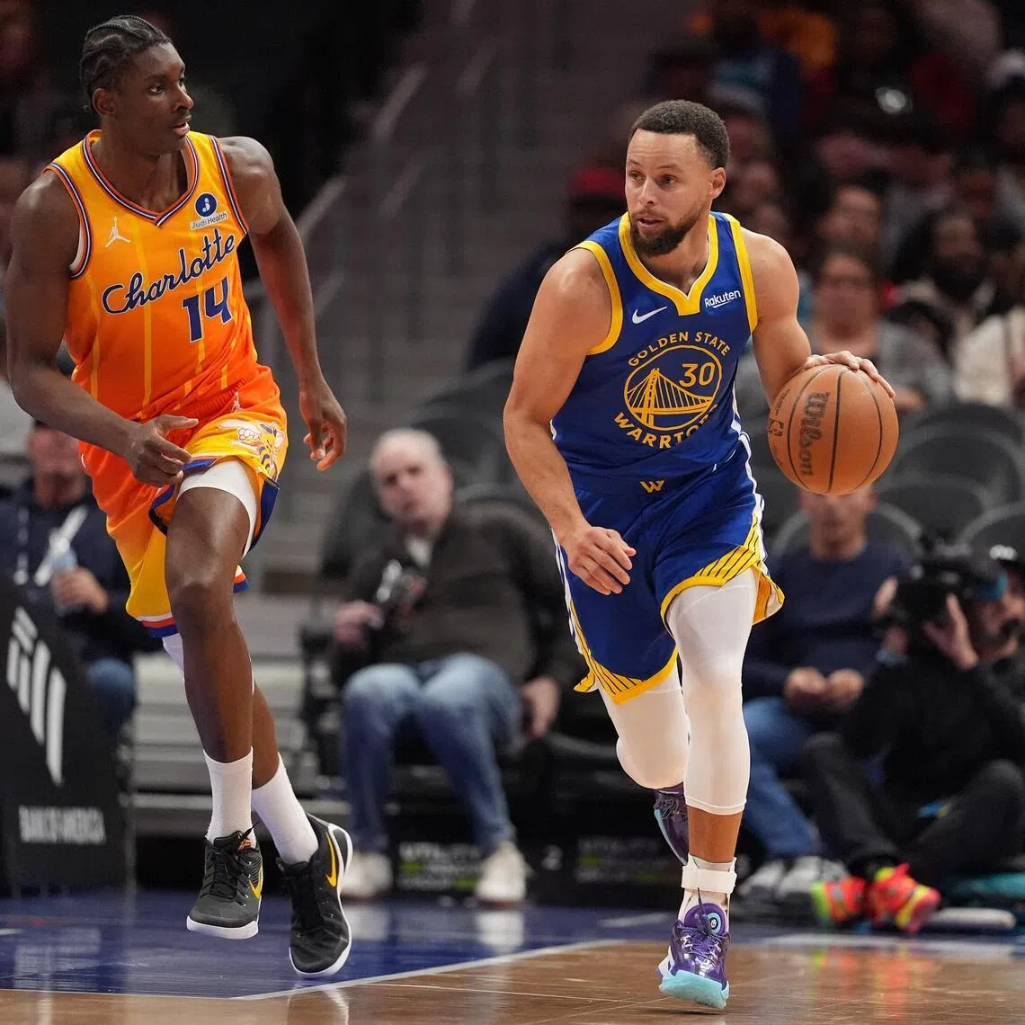 Golden State Warriors guard Stephen Curry brings the ball up court followed by Charlotte Hornets forward Moussa Diabate during the second half at Spectrum Center. 