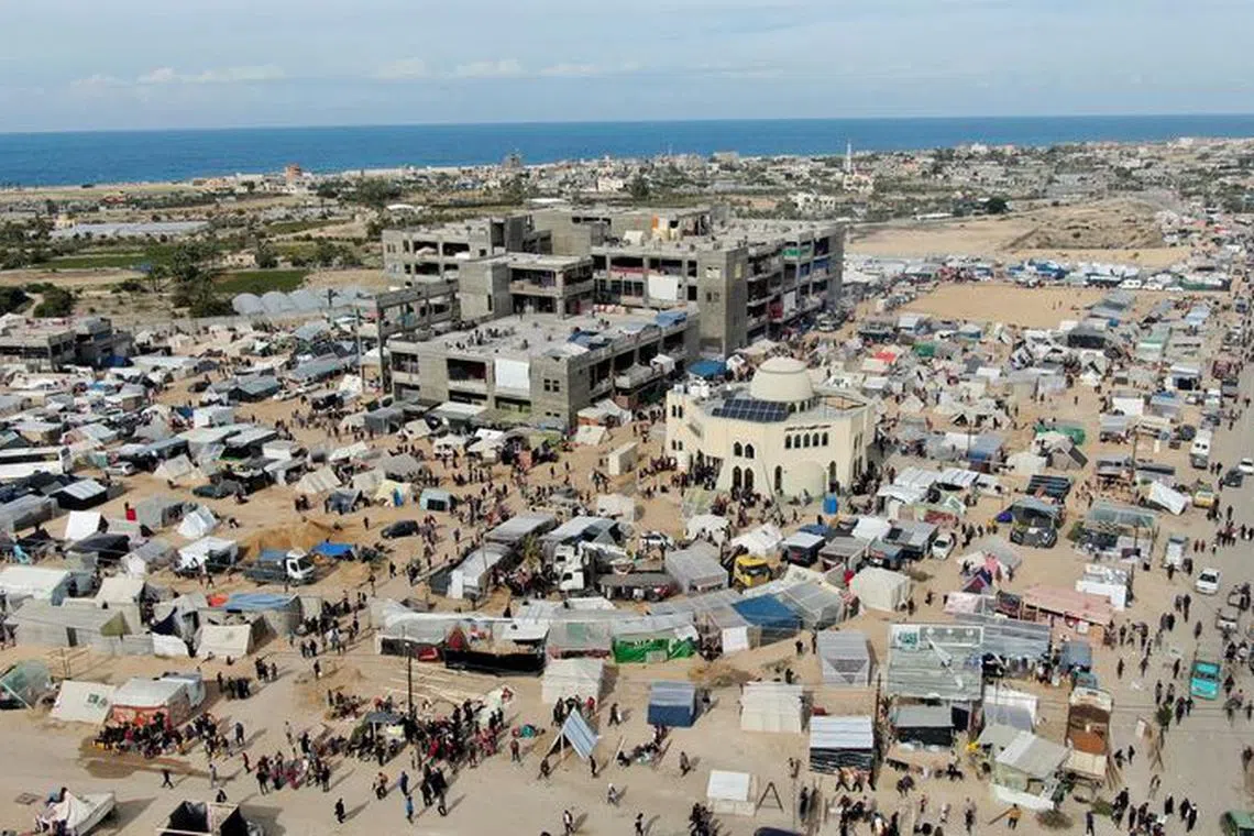 FILE PHOTO: People walk near tent camps where displaced Palestinians, who fled their houses due to Israeli strikes amid the ongoing conflict between Israel and the Palestinian Islamist group Hamas, take shelter in Rafah in the southern Gaza Strip, December 9, 2023. REUTERS/Mustafa Thraya/ FILE PHOTO