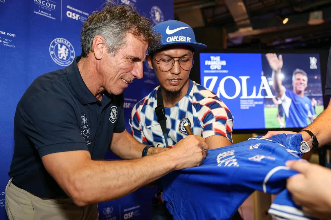 Chelsea legend Gianfranco Zola (left) signing a jersey for Chelsea fan Khidir Su'aini at Lyf Funan Singapore on Dec 1. 