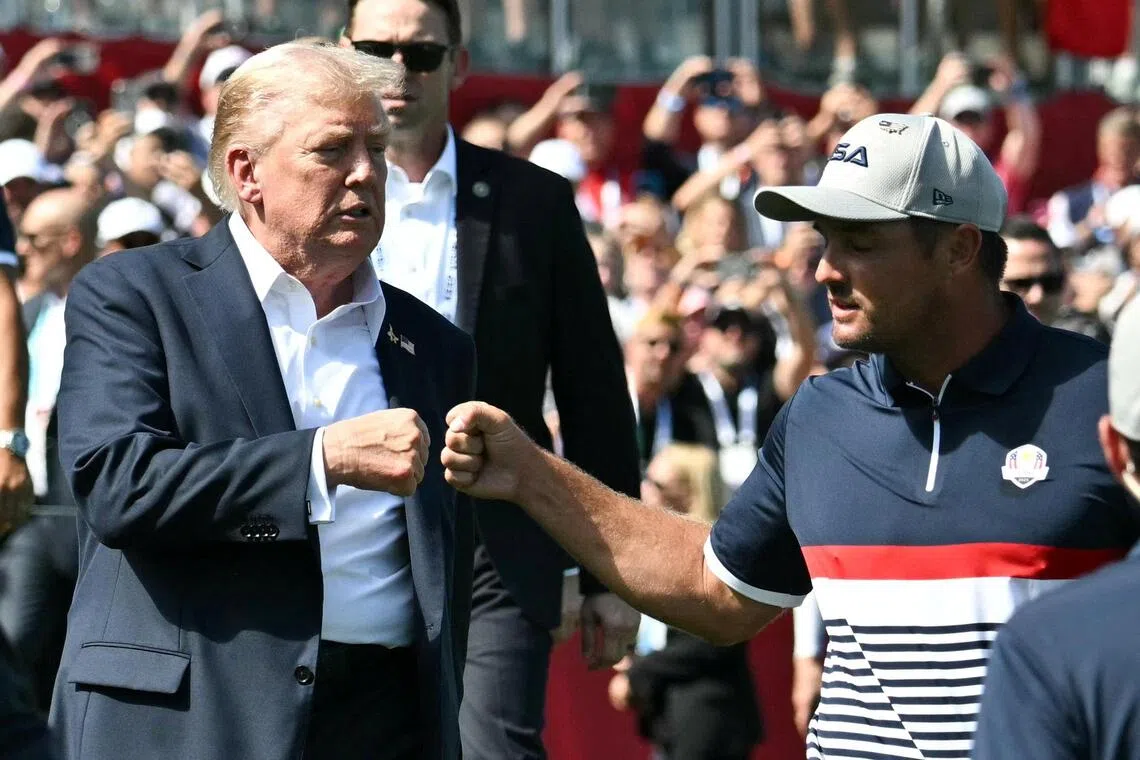 US President Donald Trump fist-bumps pro-golfer Bryson DeChambeau as he attends the 45th Ryder Cup golf tournament on Sept 26.