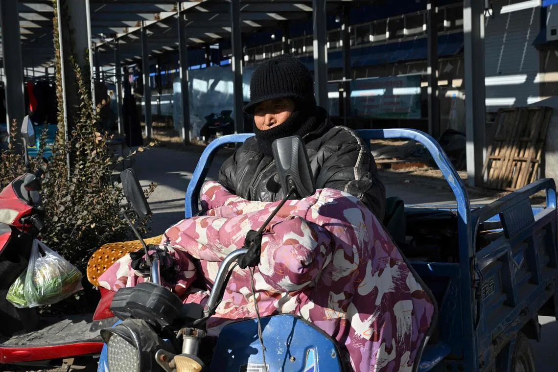 A motorist rides through a neighbourhood affected by the heating subsidy policy in Baoding city, northern China's Hebei province on Jan 7, 2026.