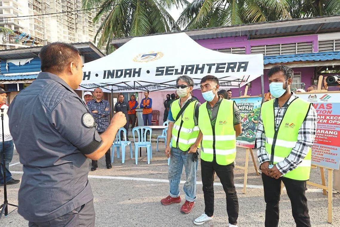 A Johor Solid Waste Management and Public Cleansing Corporation officer briefing three individuals before their community service in Johor Bahru.
