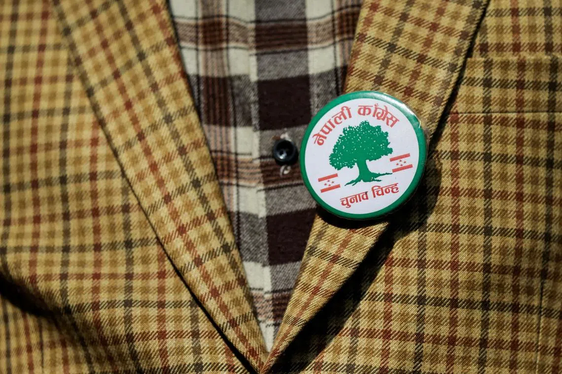 A man wearing a badge printed with the party flag and symbol of Nepali Congress takes part during an election campaign in Kirtipur, Kathmandu, Nepal, on March 1.